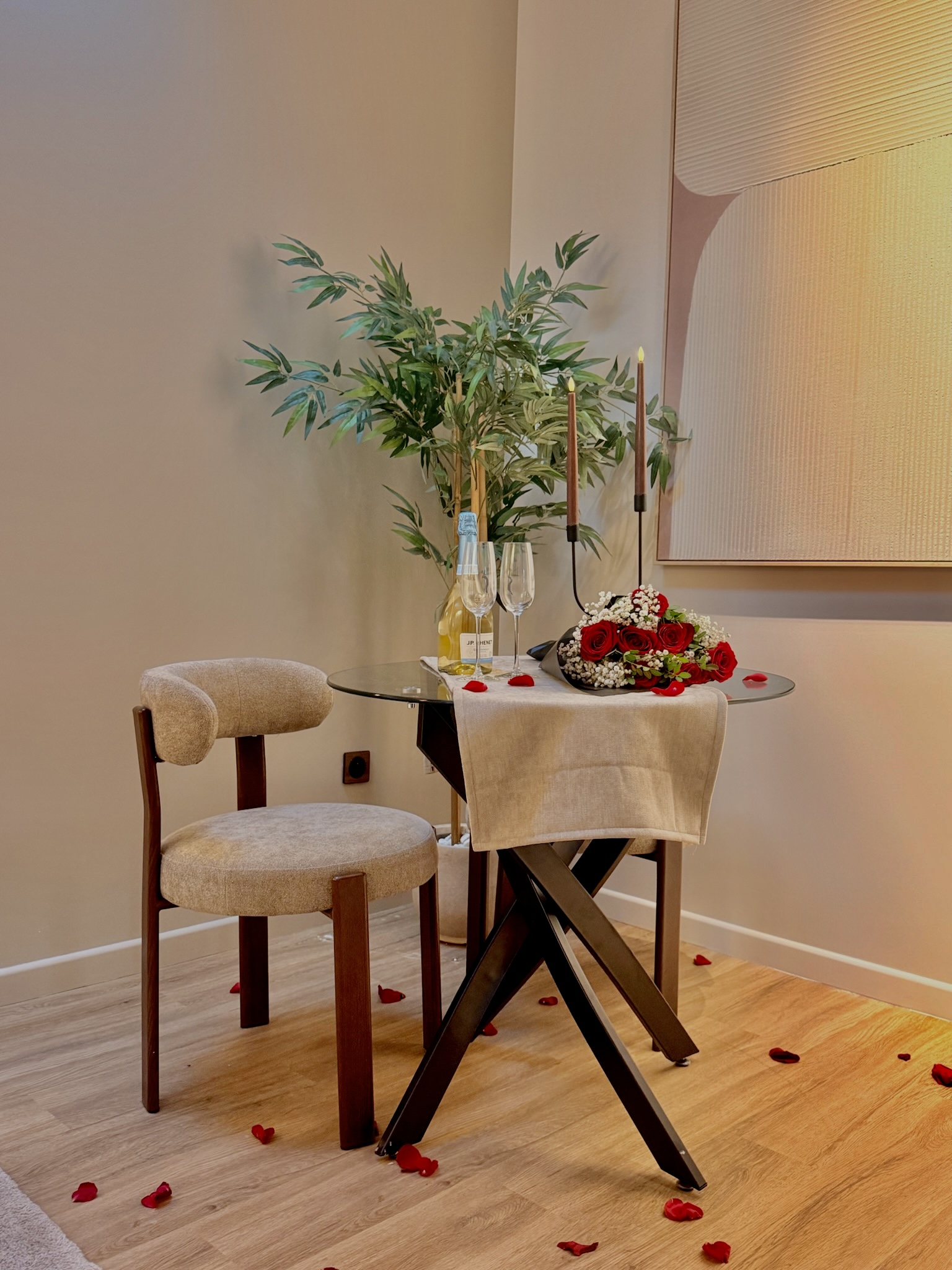 Table dressée avec roses et champagne — anniversaire en suite avec spa privatif à Argenteuil
